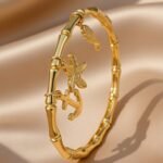 This is a gold-plated nautical-themed bamboo bangle bracelet,