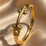 appears to be a 4U 18k yellow gold plated classical adjustable bangle bracelet.