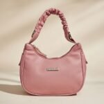 Lancaster Basic Chouchou baguette bag with a scrunchie-inspired handle in a rose antic (pink) color.