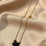lack swan pendant on a gold-toned chain,