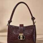 Sandro Janet leather shoulder bag in a bordeaux or dark red color.