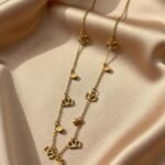 gold necklace appears to be a stylish charm or station chain necklace,