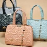 women's satchel or top-handle handbags, featuring a distinct geometric quilted pattern and a small decorative tassel charm.